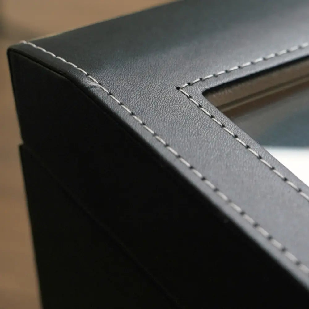 Close-up of the stitched black leather edge and glass window of the Kensington